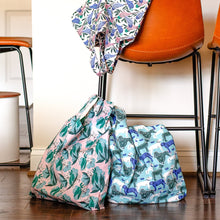 Load image into Gallery viewer, Bags made from the House Cat Jungle fabric prints shown filled, by a chair
