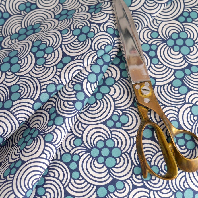 Cloud9 Fabrics Organic Cotton Fabric shown in soft folds with scissors laying on top