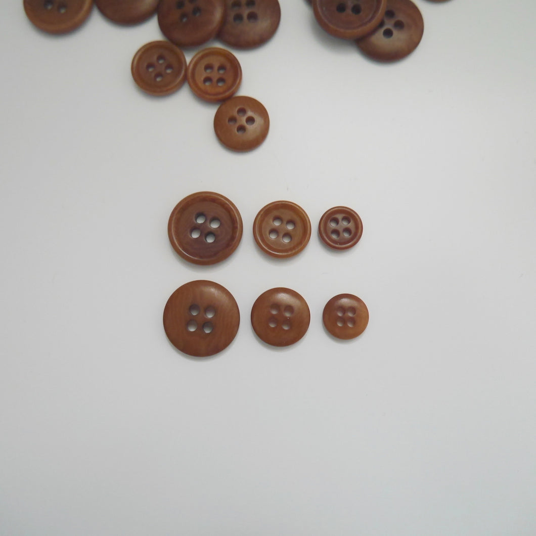4-hole corozo buttons shown in three different sizes, one side shows a smooth domed side, the other shows a flat with edged rim