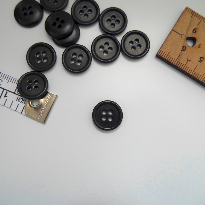 Corozo button with 4 holes, displayed amongst tape measure and ruler