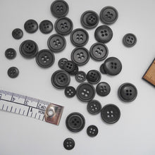 Load image into Gallery viewer, Scattering of 4-hole corozo buttons in three different sizes
