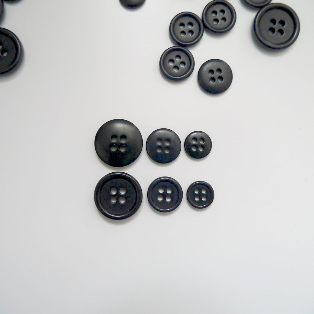 4-hole corozo buttons shown in three different sizes, one side shows a smooth domed side, the other shows a flat with edged rim
