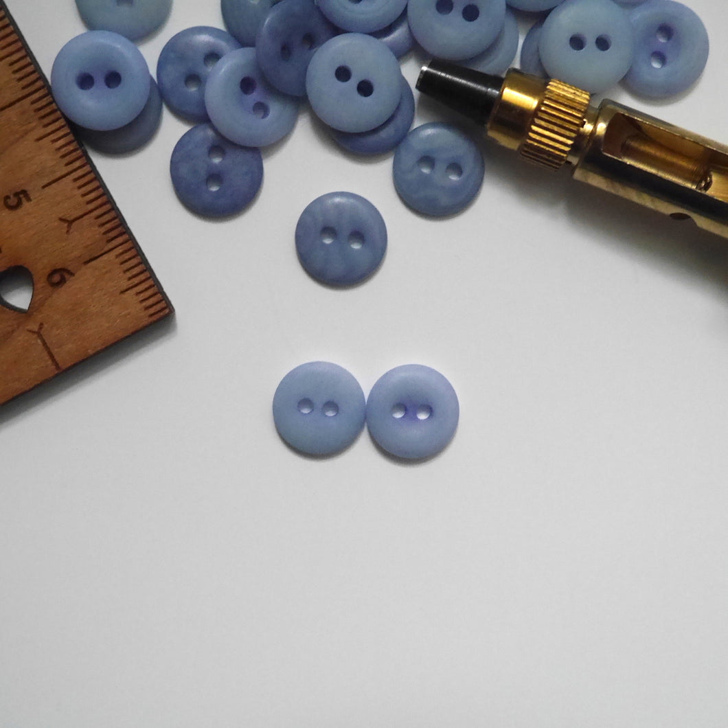 Two 2-hole corozo buttons, one showing smooth dome side, the other showing concave side