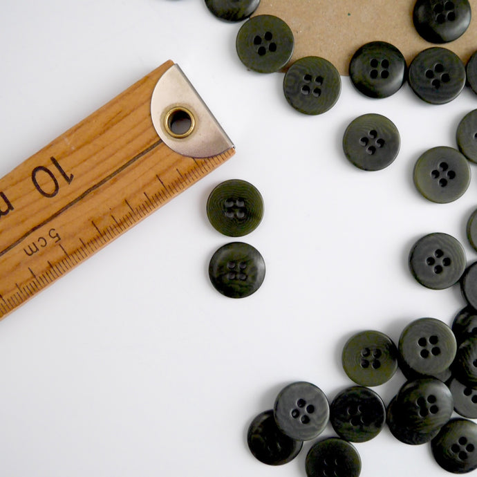 Two 4-hole buttons displayed, one with flat side, the other domed