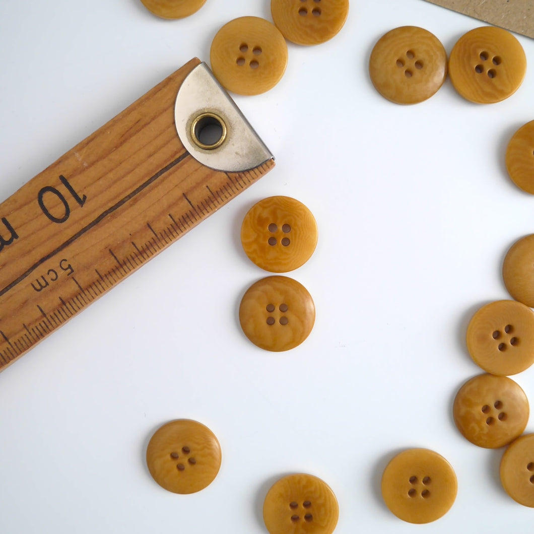 Two 4-hole buttons displayed, one with flat side, the other domed