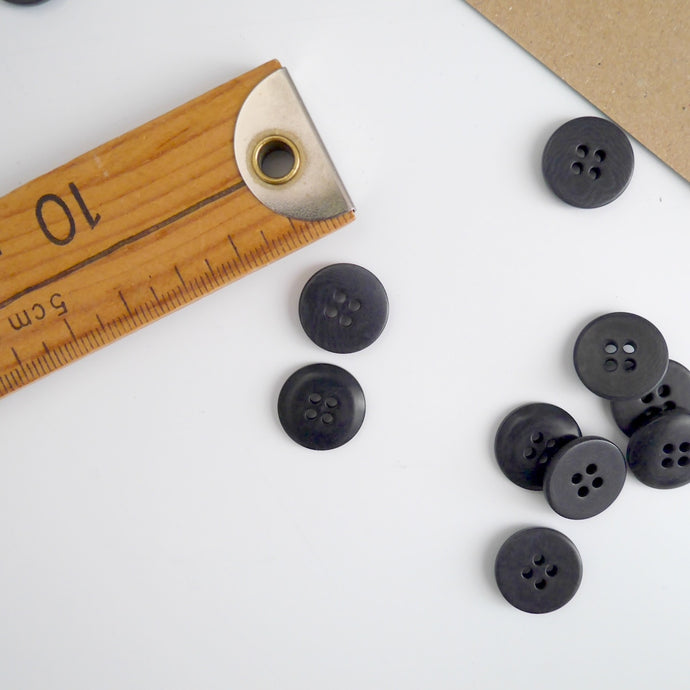 Two 4-hole buttons displayed, one with flat side, the other domed