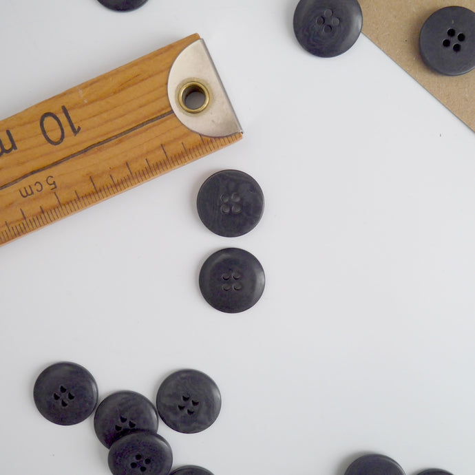 Two 4-hole buttons displayed, one with flat side, the other domed