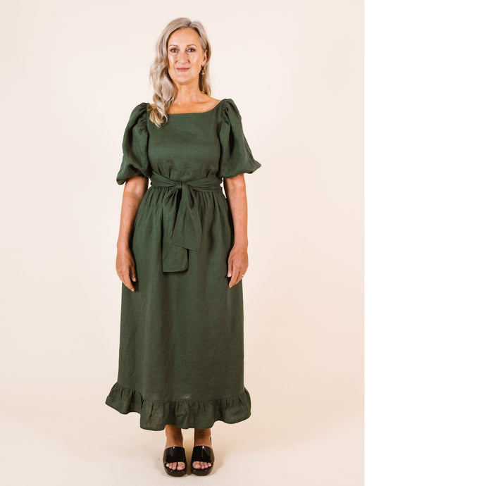 Lady wears Estella Dress with puff sleeves and frill ankle hem, tie at waist