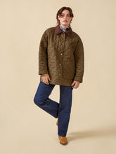 Load image into Gallery viewer, Model wears a quilted jacket, fastened up
