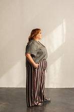 Load image into Gallery viewer, Side view of lady standing wearing a short sleeve Donny shirt tucked into trousers at front
