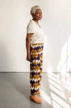 Load image into Gallery viewer, Side view of model wearing wide-leg pants with a busy print fabric
