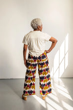 Load image into Gallery viewer, Back view of model wearing wide-leg trousers with a busy print fabric
