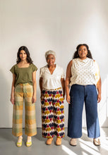 Load image into Gallery viewer, Three models of various heights and shapes stand next to one another wearing the wide-legged Flâneur Trousers in different fabrics
