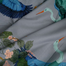Load image into Gallery viewer, Cotton fabric with pattern print of large heron in flight amongst leaves, displayed with soft folds
