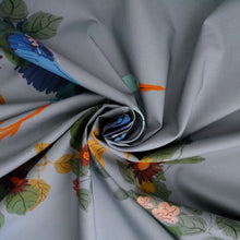 Load image into Gallery viewer, Cotton fabric with pattern print of large heron in flight amongst leaves, displayed with central swirl
