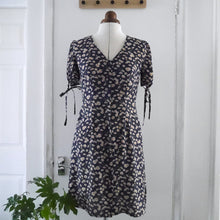 Load image into Gallery viewer, V-neck dress with short puff sleeves and ties at cuff, displayed on mannequin
