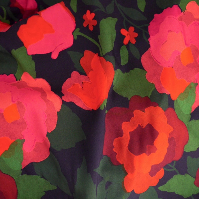 Eco Viscose fabric, close-up of a floral pattern with pink and red flowers on a dark background
