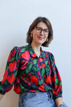 Load image into Gallery viewer, Model wearing a colourful floral blouse, made with La Roseraie Viscose fabric, in front of a plain background
