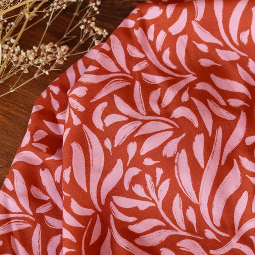 Viscose fabric shown with slight drape close up to show print of brushstroke petals 