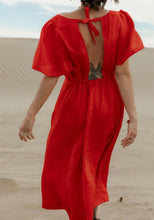 Load image into Gallery viewer, Back view of lady wearing a short-sleeve dress with centre back opening at the top with tie fastening at neck. Elasticated waistband for skirt
