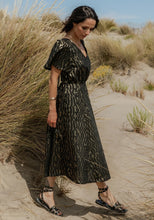 Load image into Gallery viewer, Lady wears a V-neck, short-sleeve dress with elasticated waist in a gold pattern fabric
