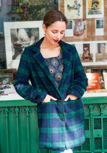 Load image into Gallery viewer, Lady wears a longline jacket coat fastened by 2 buttons, hands in flap pockets next to them
