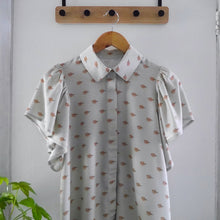 Load image into Gallery viewer, Collared shirt with short flutter sleeves made with Tranquil EcoVero Viscose fabric hangs on hanger
