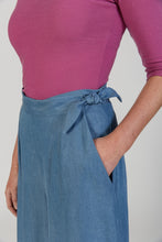 Load image into Gallery viewer, Close up detail of lady wearing Flint trousers at waist, shows the concealed side flap closure fastened with tie
