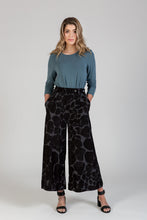 Load image into Gallery viewer, Lady wears a pair wide-leg trousers, with hands in side pockets
