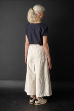 Load image into Gallery viewer, Back view of model wearing culotte trousers with patch pockets at hips and elasticated waistband at back
