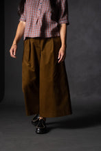 Load image into Gallery viewer, Model stands wearing wide-leg culotte trousers with waist pleats
