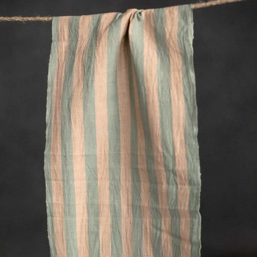 Piece of organic cotton and linen blend fabric with stripe pattern hangs over string