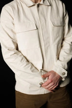 Load image into Gallery viewer, Male wears the Paynter Jacket, with four patch pockets with flaps at front, tabs with buttons at sleeves
