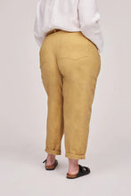 Load image into Gallery viewer, Back view of model wearing Worker Trousers with turn up cuffs, and large patch pockets at hip level
