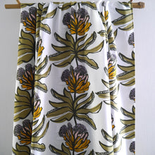 Load image into Gallery viewer, EcoVero Viscose fabric hangs from a bar, with floral stem print, repeat pattern.
