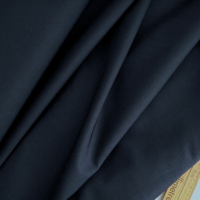 Organic Cotton Fabric displayed in soft folds next to a wooden ruler