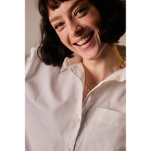 Load image into Gallery viewer, Model smiles, wearing an open-collared, button-up shirt made with Oxford Cotton Fabric
