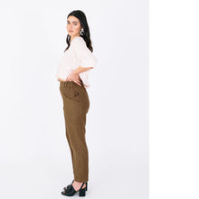 Load image into Gallery viewer, Lady stands in side profile, wearing trousers with elasticated waistband, and cross over pocket panels at hipline
