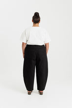 Load image into Gallery viewer, Back view of lady wearing barrel leg trousers with patch pockets at hip level
