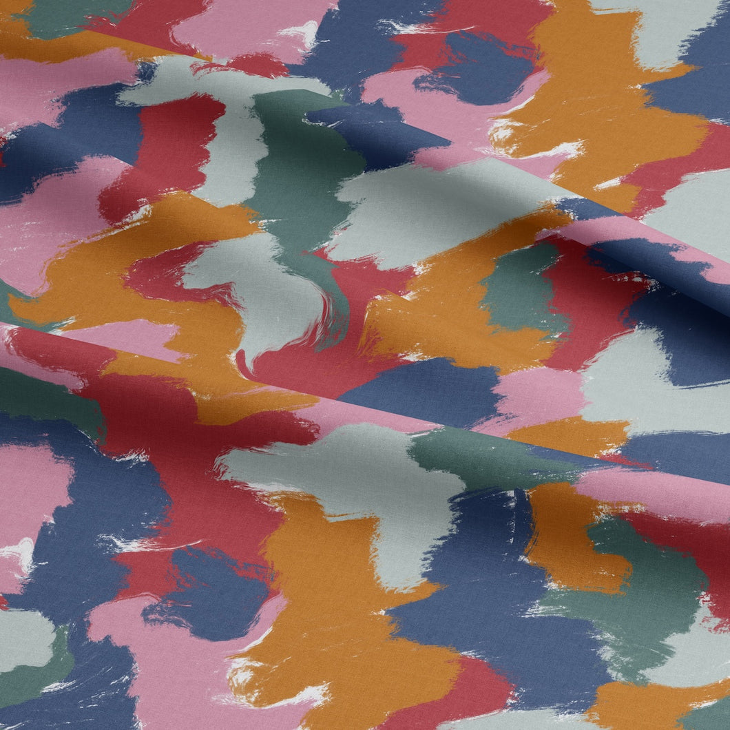 Vibrations EcoVero Viscose Fabric shown with soft folds in drape, with a multicoloured brush patches print