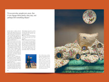 Load image into Gallery viewer, Magazine spread with page of floral cushions and a fabric moonlit sky on the right, text on the left.

