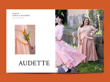 Load image into Gallery viewer, Two-page magazine spread features two images of models wearing a short sleeve top with a gather detail along the hem, with a matching full skirt. Alongside page titled "Audette"
