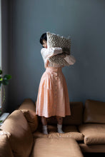Load image into Gallery viewer, Model wears a checkered buttoned-up skirt holding a patterned pillow.
