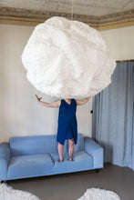Load image into Gallery viewer, Model pretends to hold a large cloud lamp, stands on sofa wearing a sleeveless dress, above-knee length with side panel details pulled to the centre tie.

