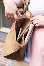 Load image into Gallery viewer, Close up view shows a tote bag carried on shoulder, showing on various inner compartments and pockets
