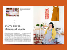 Load image into Gallery viewer, Magazine spread of article titled &quot;Sonya Philip: Clothing and Identity&quot; with a lady in an apron sat in front of sewing machine
