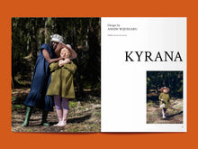 Load image into Gallery viewer, Magazine spread features two ladies hugging, both wearing a dress with gathered tier at hem, next to title: &quot;Kyrana&quot;.
