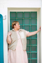 Load image into Gallery viewer, Lady stands in a doorway, wearing a fleece vest top with zip chest pocket, worn open over a short sleeve dress
