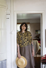 Load image into Gallery viewer, Model stands in doorway, wearing blouse with pleated shoulder seams
