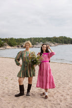 Load image into Gallery viewer, Two models on beach wearing long sleeved, tiered dresses; one short length, one midi.
